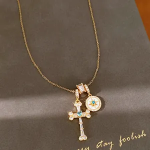 Close-up of 18k gold plated necklace featuring zircon cross and star medallion pendants