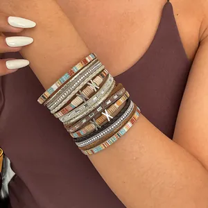 Close-up of Bohemian multi-layer leather bracelet with rhinestones and silver X charms