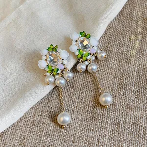 Nahaufnahme von eleganten Blumensteckern mit Kristallakzenten und Perlentropfen