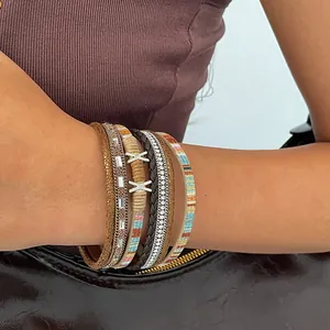 Detailed view of bohemian multi-layer leather bracelet with rhinestones on a wrist.