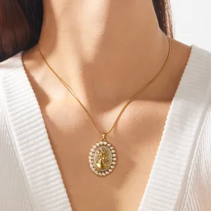 Gros plan sur un collier à pendentif ovale vintage doré avec incrustation de perles