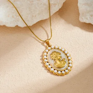 Détail d'un collier pendentif ovale rétro français avec tête dorée et perles incrustées