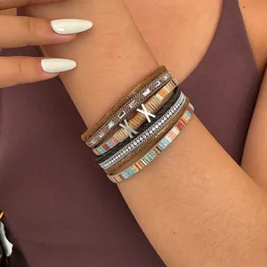 Detailed close-up of ethnic multi-layer leather braided bracelet with rhinestones