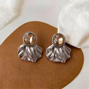 Pendientes vintage plateados con gema ovalada marrón y diseño de metal plisado.