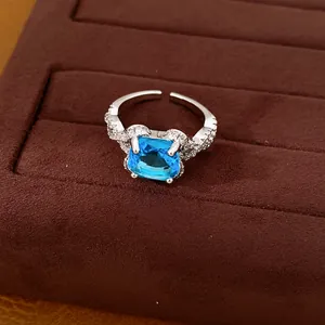 Makroaufnahme eines silberfarbenen, verstellbaren Rings mit blauem Zirkonstein.
