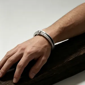 Detailaufnahme eines industriellen Nietarmbands aus Titanstahl mit Scharnierverschluss