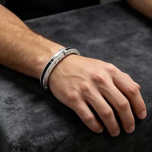 Detailaufnahme eines industriellen Titanstahlarmbands mit Nieten am Herren Handgelenk