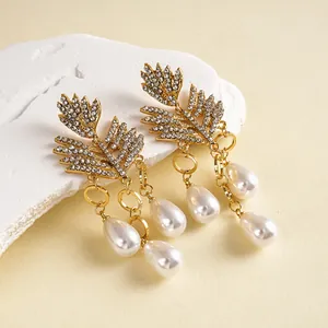 Elegante gouden blad oorknopjes met fonkelende kristallen en druppelparel kwastjes