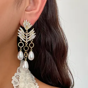 Detail van de luxe strass oorbellen in bladvorm met parel hangers