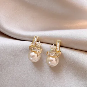 Close-up of 14k gold-plated star pearl earrings with sparkling zircon accents