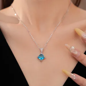 Detail einer Silberkette mit einem strahlend blauen Zirkonia-Rautenanhänger