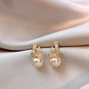 Detailed macro view of gold-plated star earrings with shimmering zirconia and elegant pearls