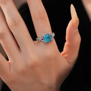 Makro-Detail eines eleganten Rings mit blauem Zirkonia und geflochtenem Silberband