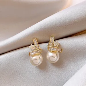Detailed view of 14k gold-plated star and pearl stud earrings with sparkling zircon