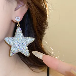 Detailed close-up showing the sparkling pave rhinestones on star dangle earrings