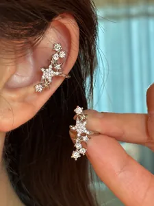 Gros plan d'un ear cuff en zircon étoilé montrant l'effet de port et le design poli.