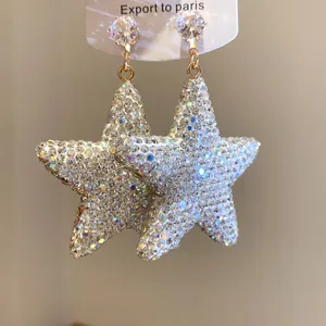 Macro detail of sparkling star drop earrings with pave-set cubic zirconia.