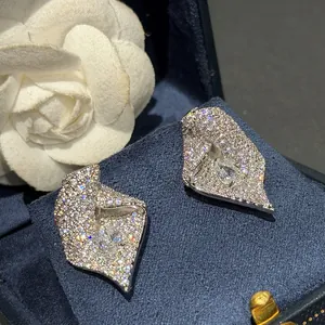 Détail de boucles d'oreilles clous en forme de tulipe serties de zircons étincelants.