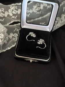 Détail des boucles d'oreilles en zircon étincelant dans un élégant coffret cadeau noir.