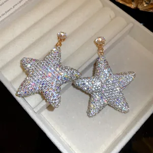 Elegant sparkling star drop earrings with iridescent rhinestones in a velvet jewelry box