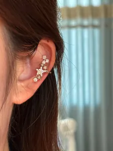 Vue détaillée d'un ear cuff en forme d'étoile avec zircons porté sur l'oreille.