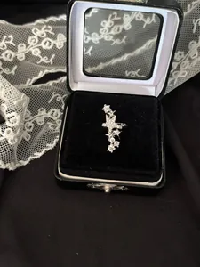Vue détaillée d'un clip d'oreille étoile en zircon dans un écrin noir avec de la dentelle