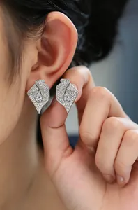 Gros plan de boucles d'oreilles élégantes en forme de tulipe en zircone sur l'oreille du mannequin