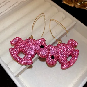 Close-up view of pink rhinestone-encrusted pony-shaped drop earrings presented in jewelry box