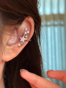 Gros plan d'un ear cuff étoile en zircon étincelant élégamment porté sur l'oreille