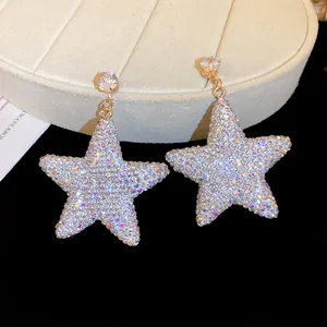 Detailed macro view of sparkling star-shaped pendant earrings with pave-set zircon stones