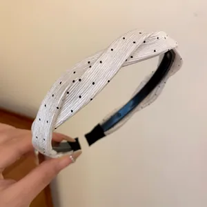 Eleganter weißer gepunkteter Stoffhaarreif mit Knotendesign für modisches Haarstyling für Damen.