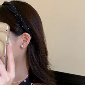 Nahaufnahme eines modischen schwarz gepunkteten Stoff-Haarreifens für einen High-Skull-Look.