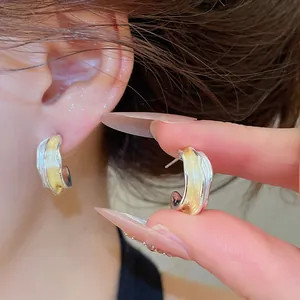 Detailansicht der unregelmäßigen wellenförmigen C-Ohrringe mit gelbem Emaille-Design