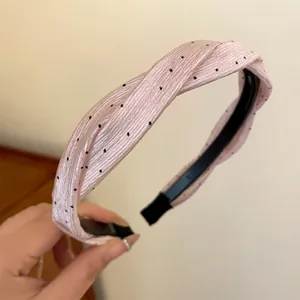 Detailansicht eines rosa gepunkteten Haarreifs mit elegant gewickeltem Stoffdesign