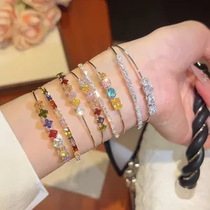 Close-up of sparkling 18k gold plated bangles with colorful zircon stones on wrist
