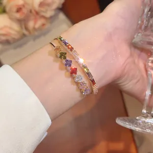 Detailed close-up view of elegant double-layer gold bangle with shimmering rainbow square zirconia