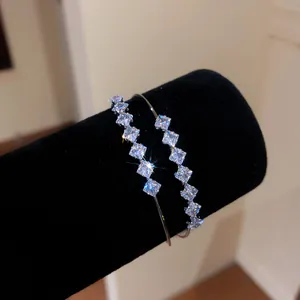 Detail view of 18k gold plated double layer open bangle with sparkling square zircons.