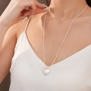 Detailed view of a minimalist silver heart necklace featuring an elegant star-dotted pattern
