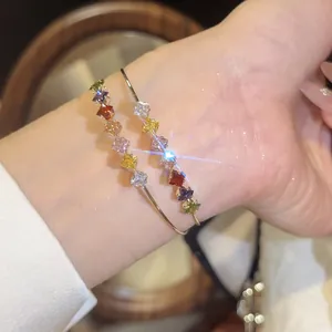 Macro view of 18k gold plated double-layer open bangle with sparkling colorful cubic zirconia