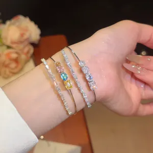 Detailed view of luxury 18k gold plated bracelets with sparkling colorful zircons on a wrist