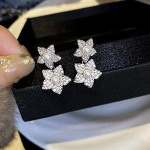 Close-up detail of luxury silver needle drop earrings featuring pavé crystals and pearls