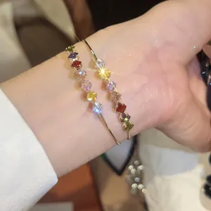 Close-up of 18k gold plated bangle featuring multi-colored square-cut sparkling zircons.