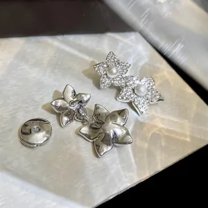 Close-up of micro-inlaid zircon details and polished silver back of floral earrings