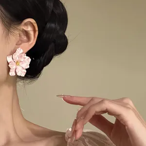Detailansicht eleganter rosa Blumenstecker, getragen von einem Modell, sanftes Licht.