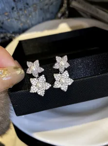 Exquisite detailed macro shot of micro-pave zircon flower stud earrings with a central pearl