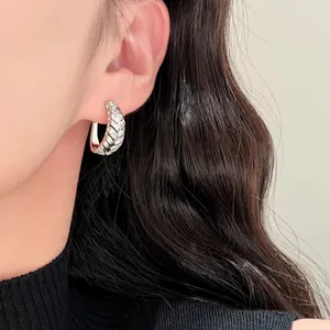 Nahaufnahme des versilberten Creolen-Ohrrings mit fein geometrischer Zirkon-Einlage