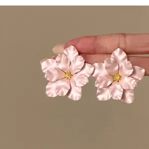 Nahaufnahme von eleganten rosa Blumenohrsteckern mit filigranen Details für stilvolle Damen
