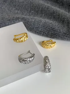 Detailansicht vergoldeter 18k Creolen mit eleganten geometrischen Zirkonia-Webmustern.