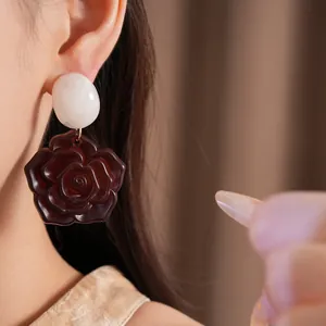 Gros plan d'élégantes boucles d'oreilles rose en résine avec clou ovale sur un mannequin