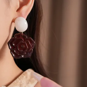 Gros plan détaillé montrant la texture élégante et l'effet de port de cette boucle d'oreille rose